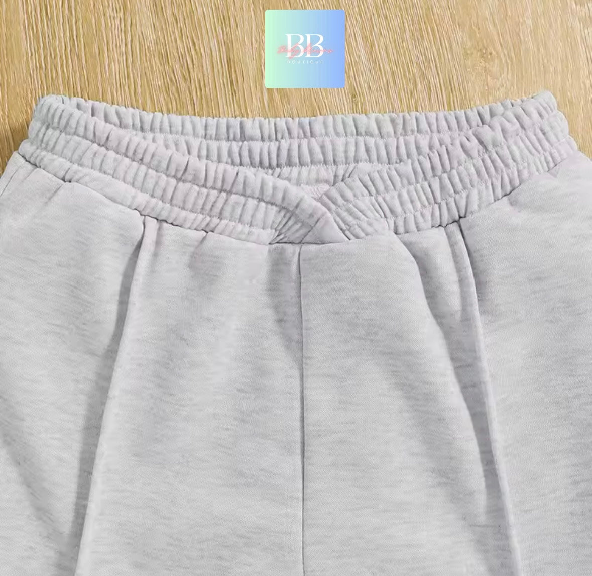 Gray sweatpants with a brand logo on a wooden surface