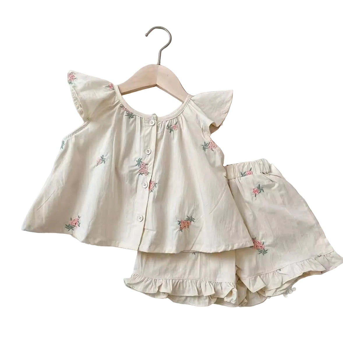 Children's beige outfit with floral embroidery on a light background
