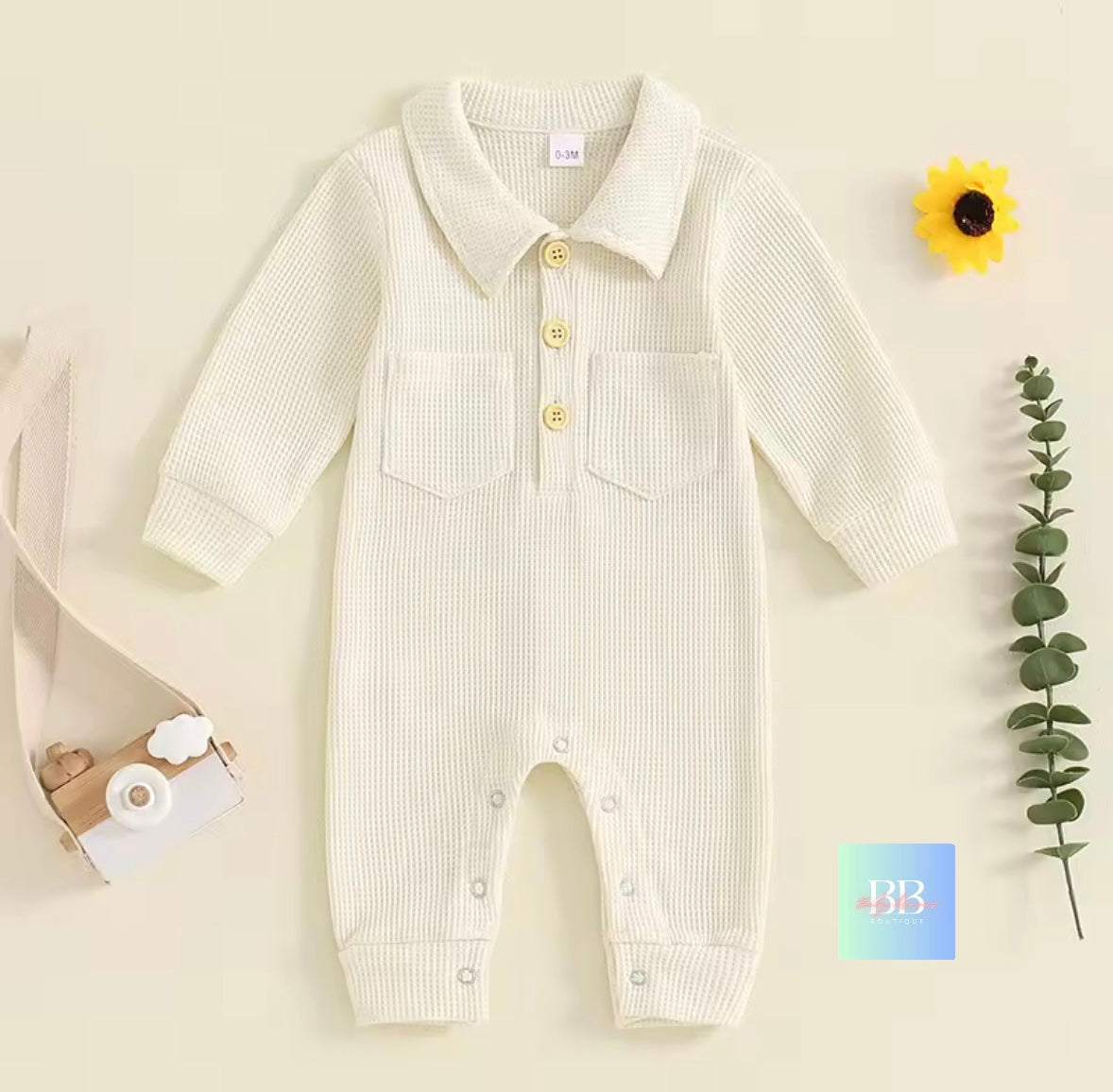 Baby romper with long sleeves on a beige background