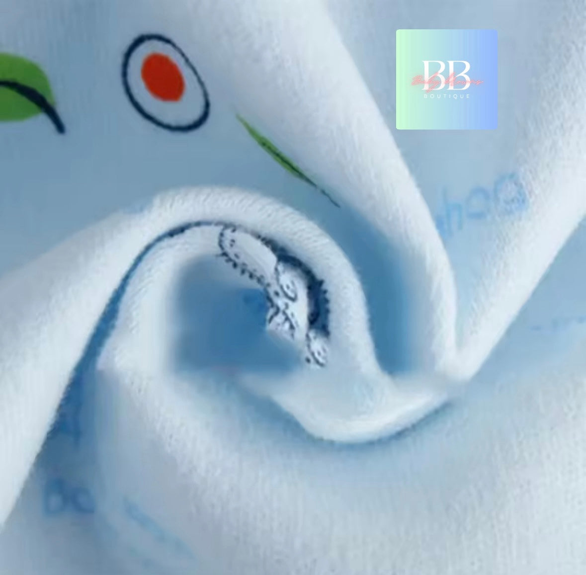 Close-up of white fabric with colorful designs and 'BB' logo.