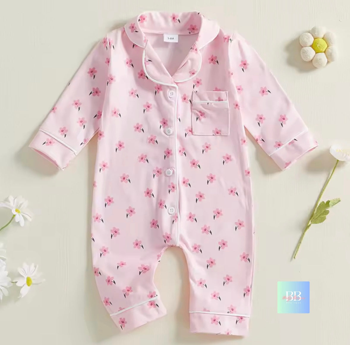 Pink baby onesie with floral pattern on a light background