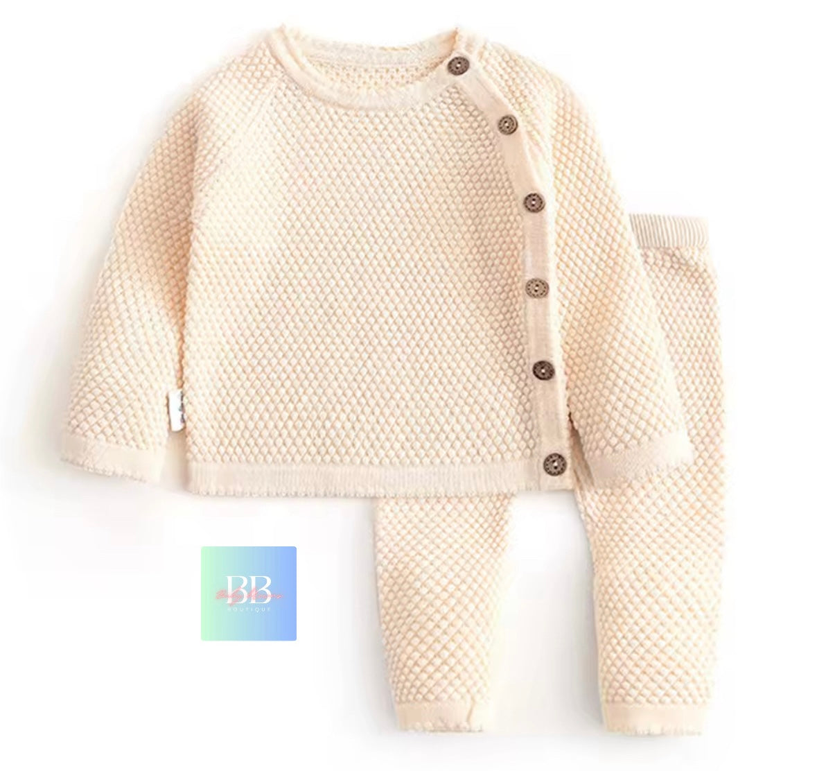 Beige textured baby outfit with buttons on a white background