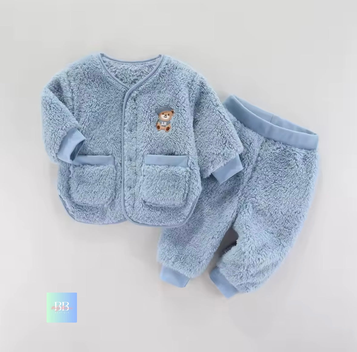 Blue baby outfit with teddy bear design on a light gray background