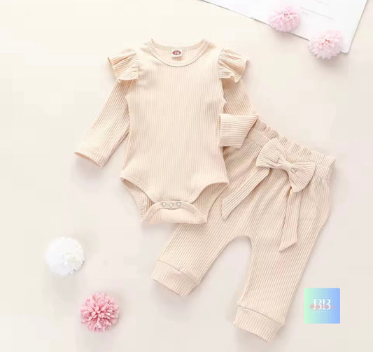 Baby outfit with beige bodysuit and pants on a light background