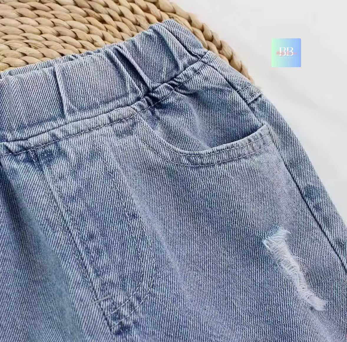 Close-up of a blue denim pocket with a woven mat background