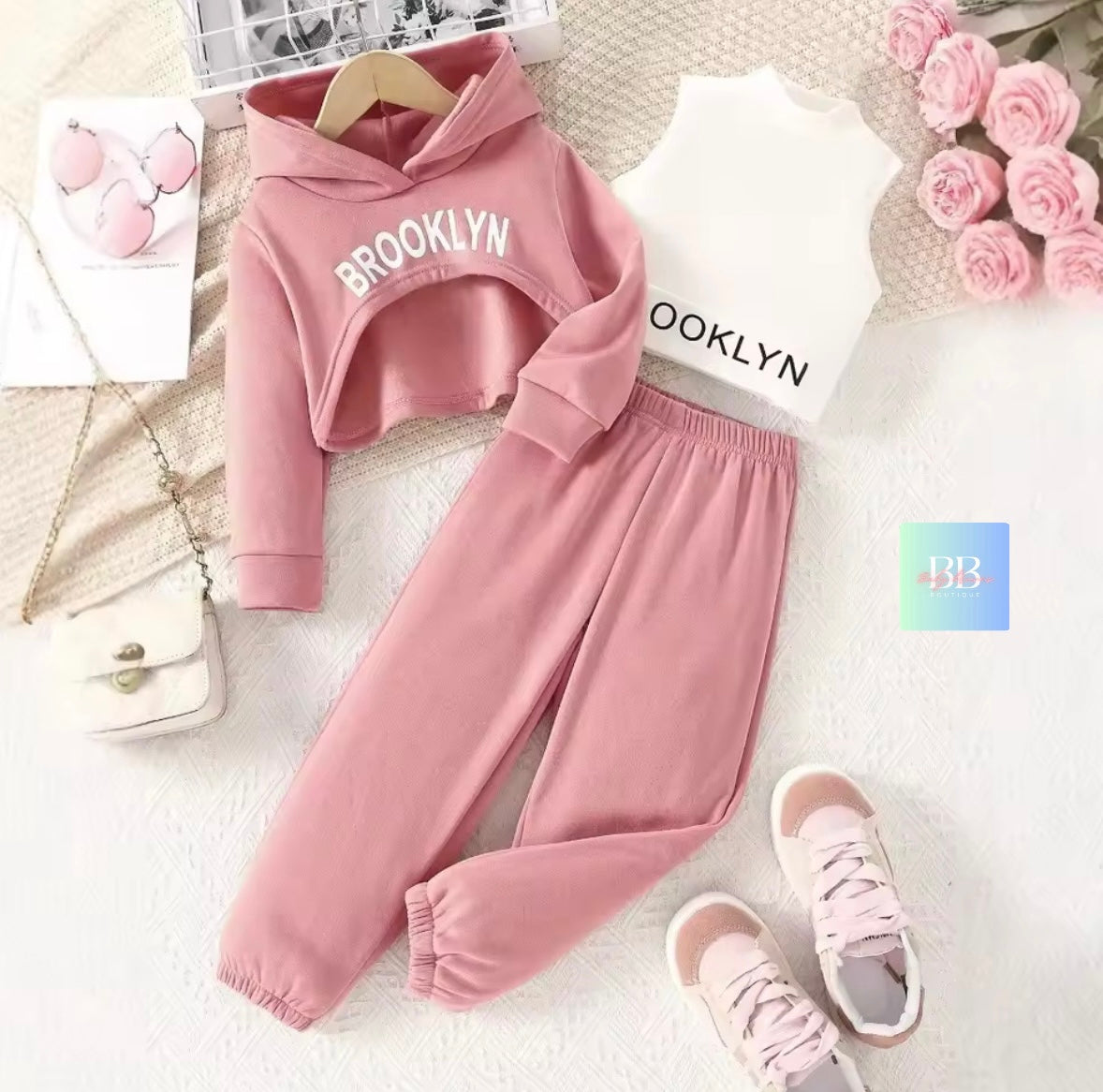 Pink 'Brooklyn' hoodie and pants set with matching shoes on a light background