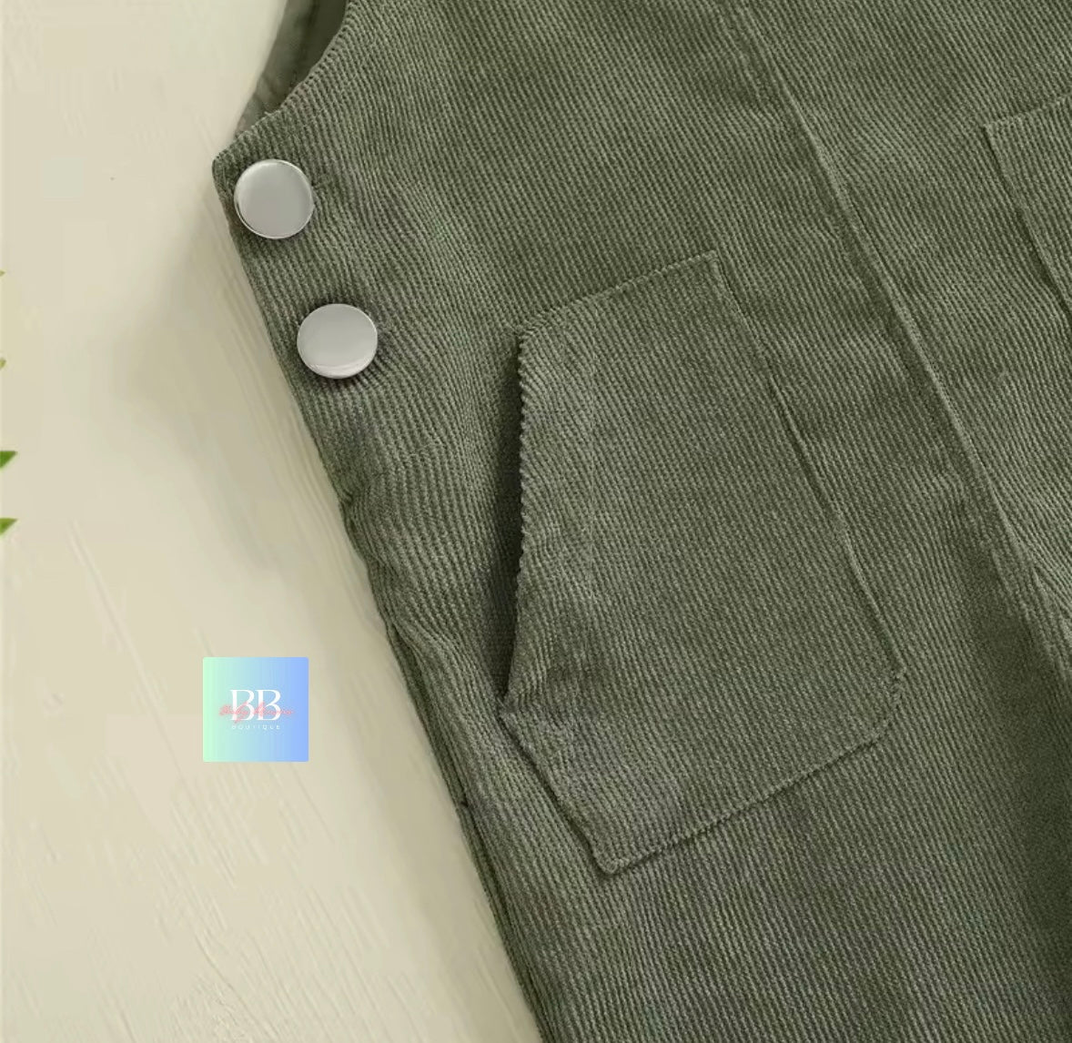 Green corduroy pants with buttons on a light background