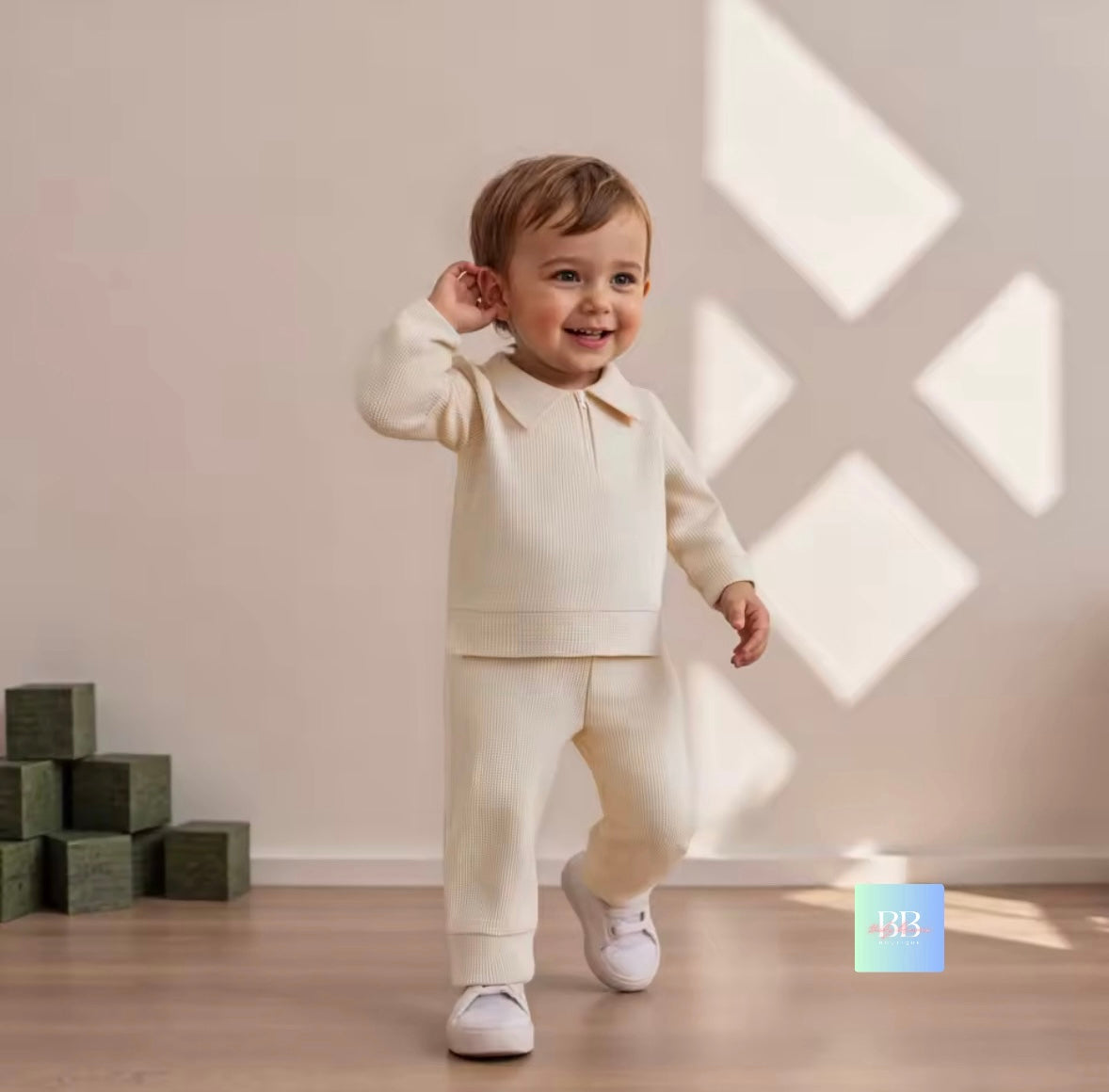 Child in a white outfit standing in a room with sunlight casting patterns on the wall.