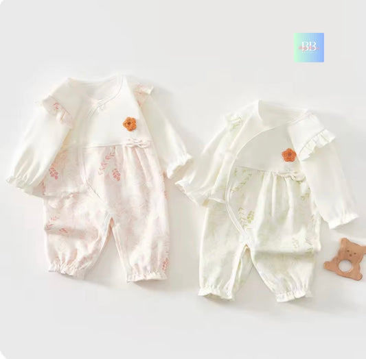 Two baby rompers with ruffled sleeves on a white background