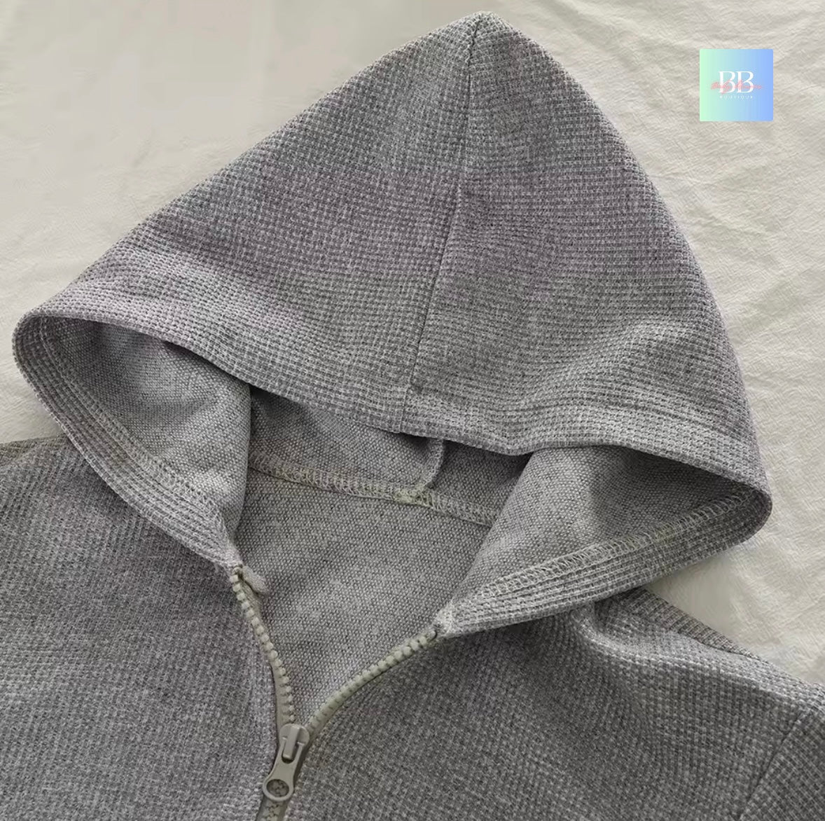 Gray hoodie with a zipper on a light gray background