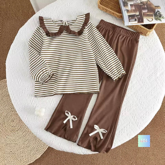 Children's outfit with striped shirt and brown pants on a white surface.