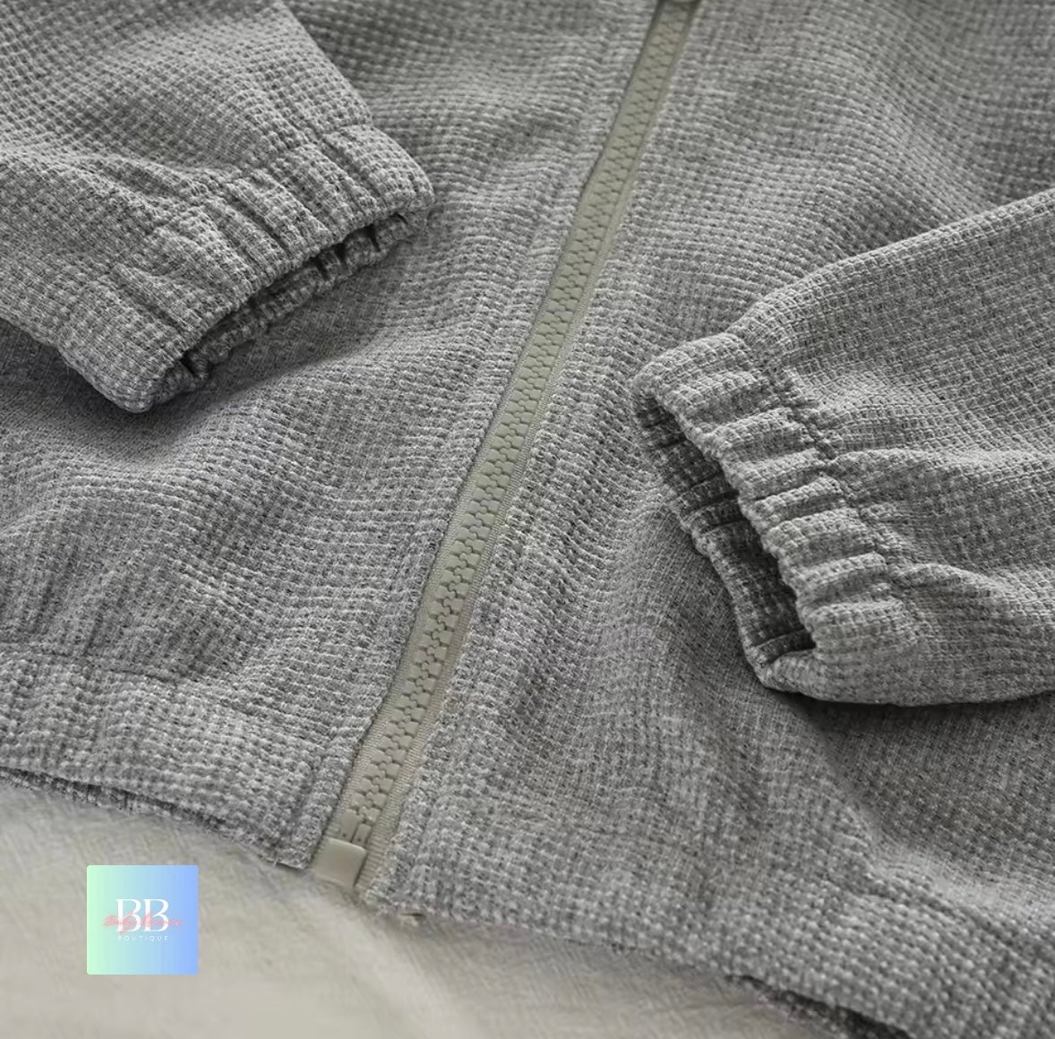 Close-up of a gray textured jacket with a zipper on a light background