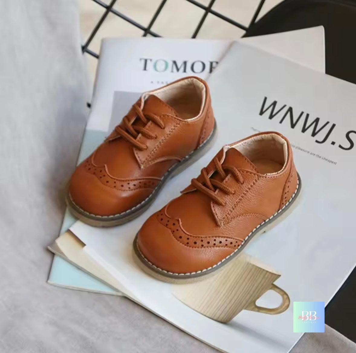 Pair of brown children's shoes on a magazine