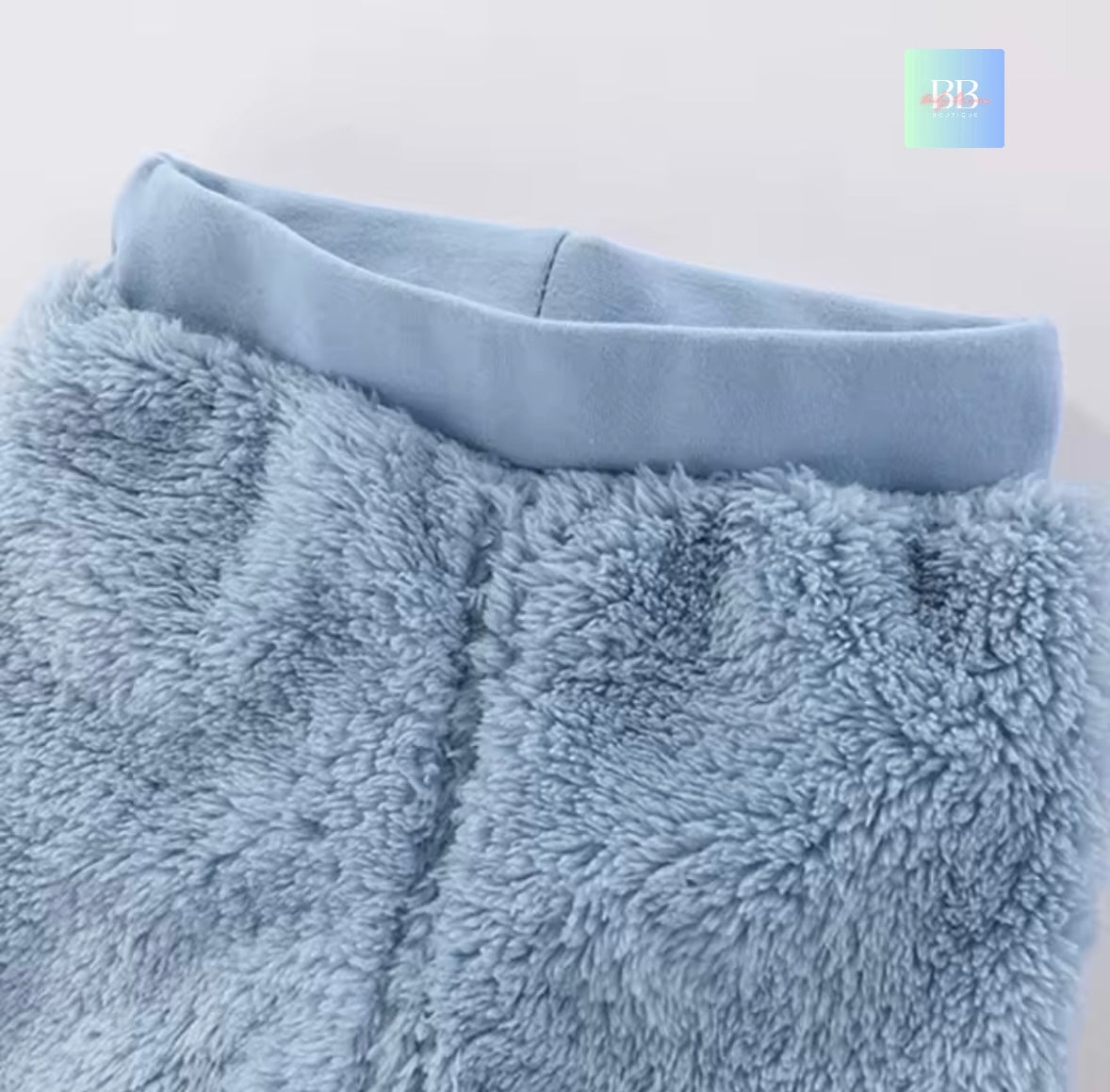 Close-up of a fluffy blue blanket with a plain background