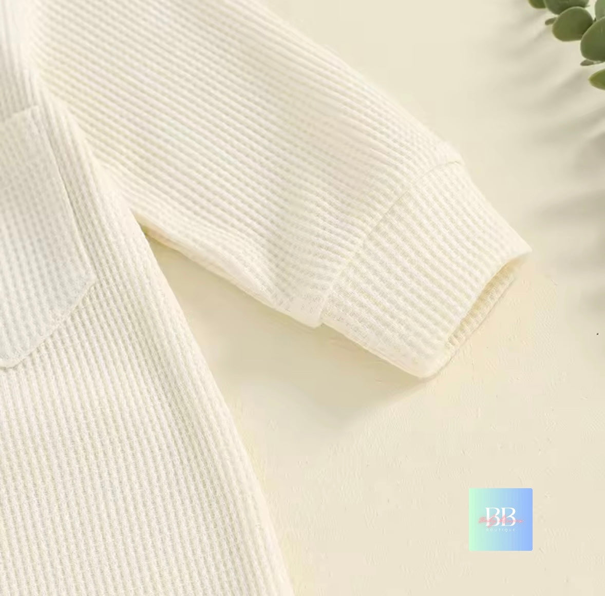 Close-up of a textured fabric with a brand logo in the corner.