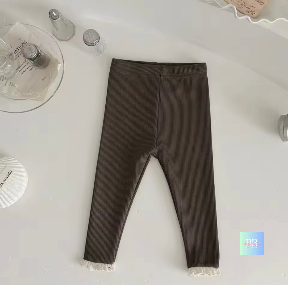 Brown leggings with lace trim on a white surface