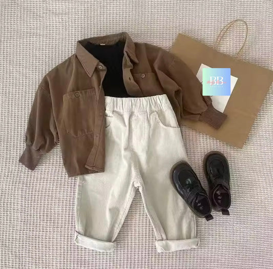 Brown jacket, white pants, black shoes, and a brown paper bag on a textured surface.