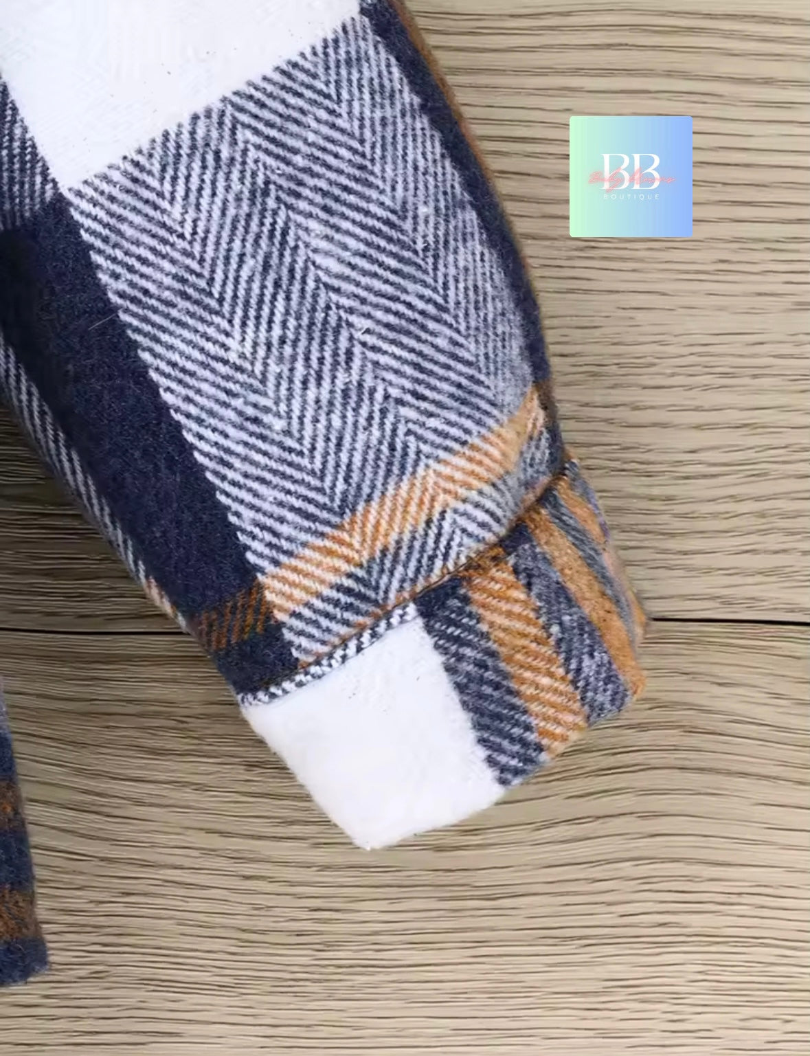 Plaid blanket with a visible brand label on a wooden surface