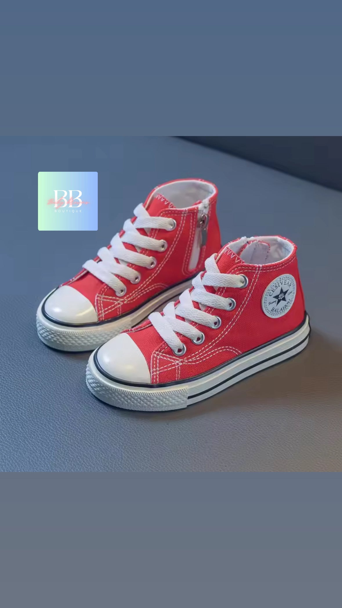 Red high-top sneakers with white laces on a gray surface