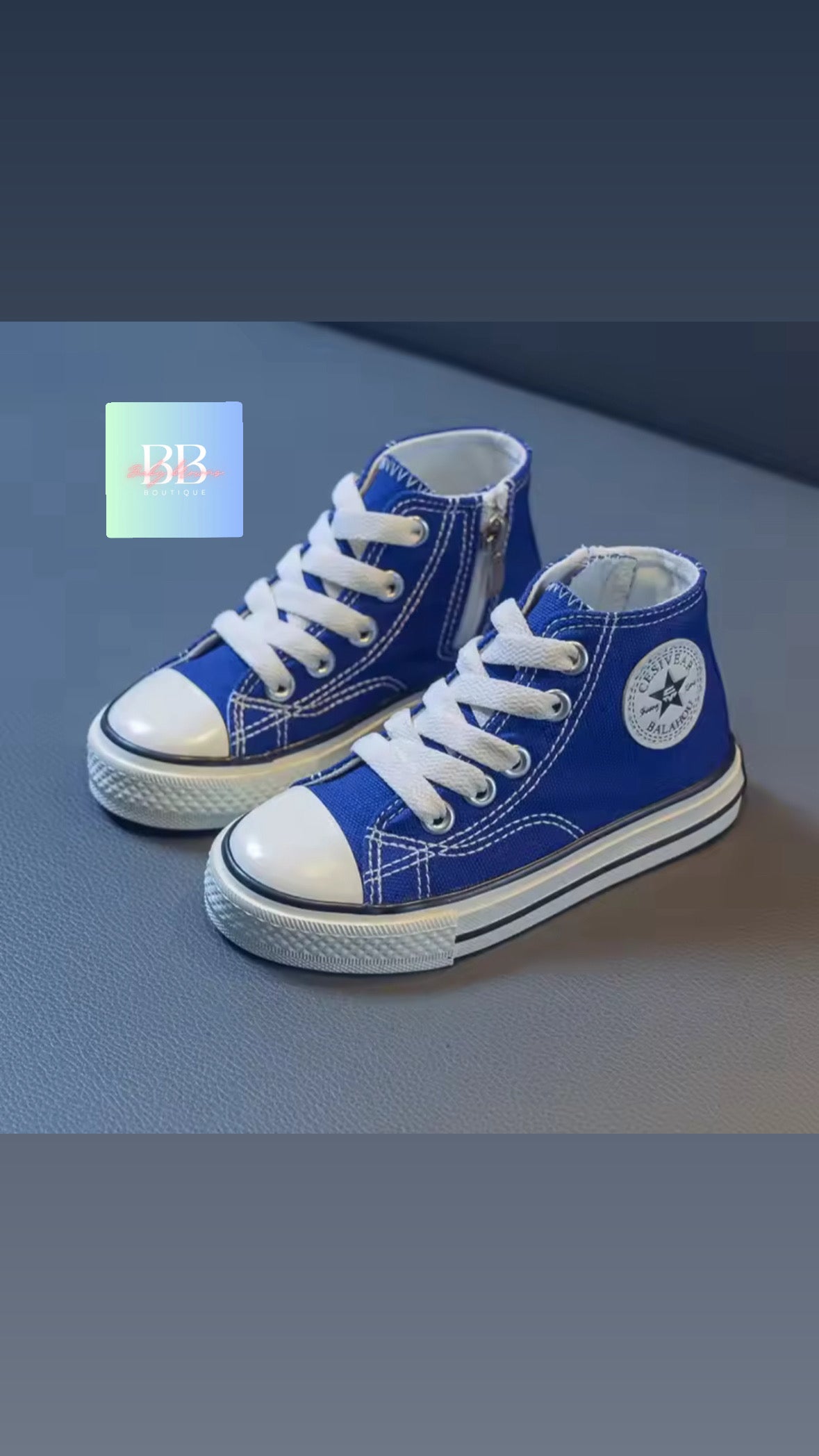 Pair of blue high-top sneakers with white laces on a gray background
