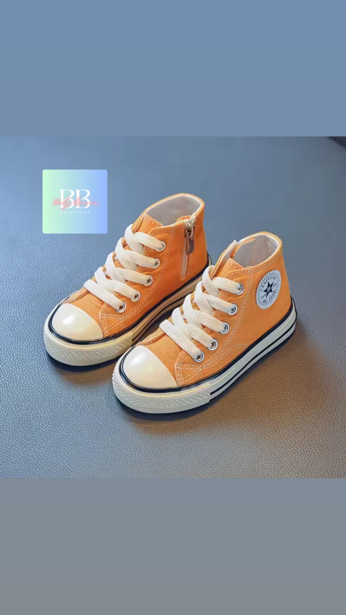 Pair of orange high-top sneakers with white laces on a blue background