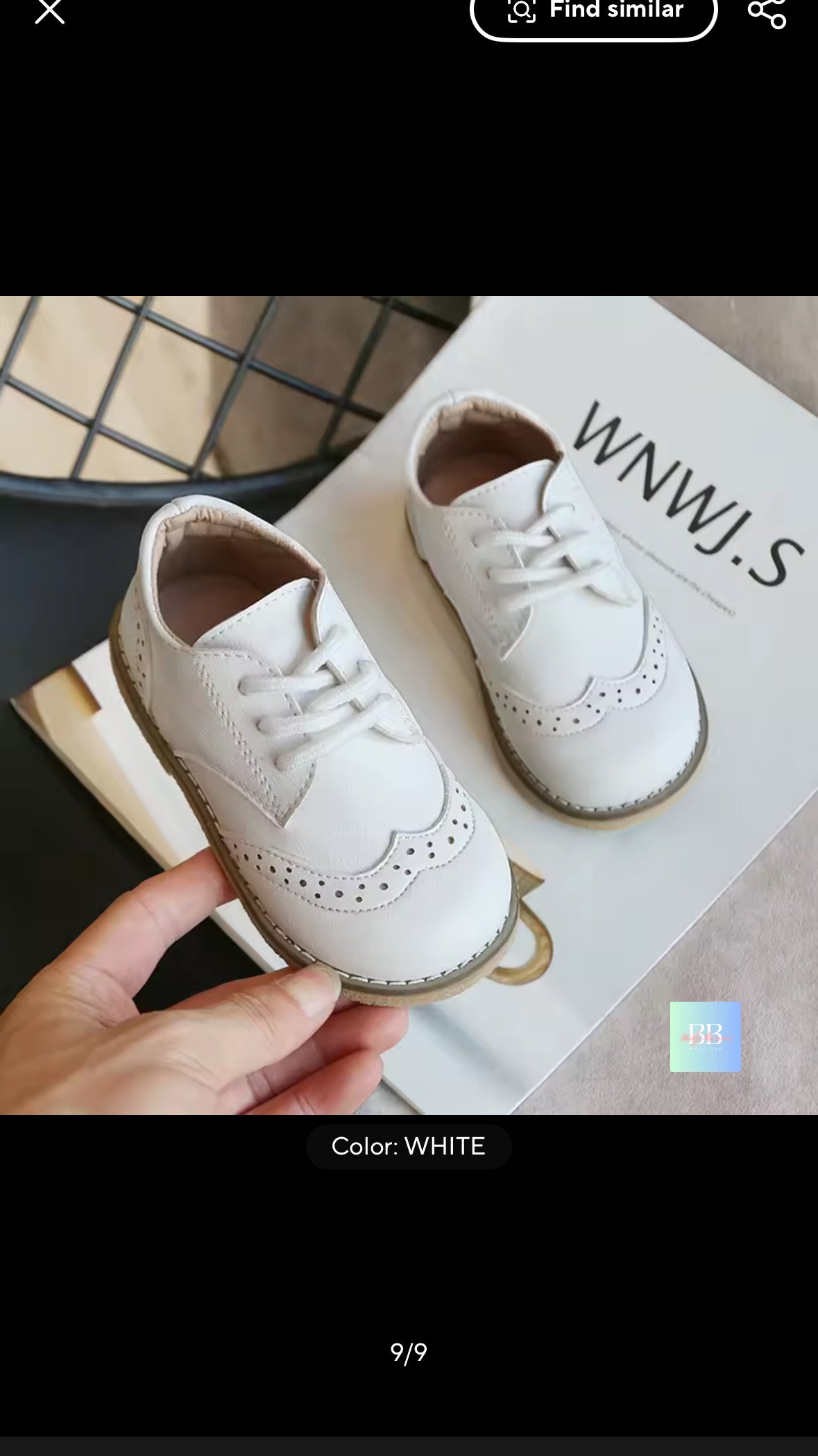 White shoes being held with a branded box in the background