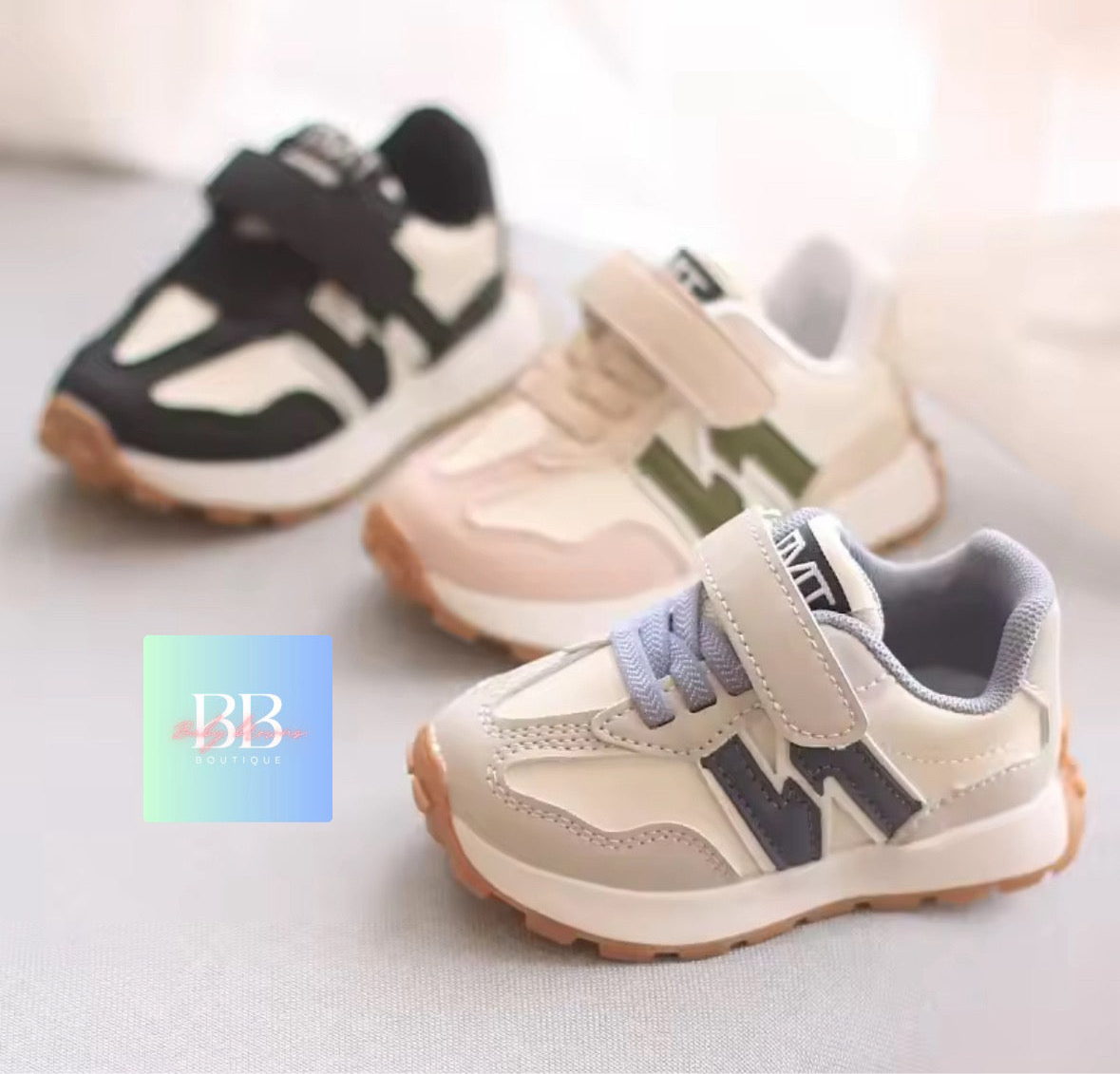 Three pairs of children's sneakers on a light background with a brand logo in the corner.