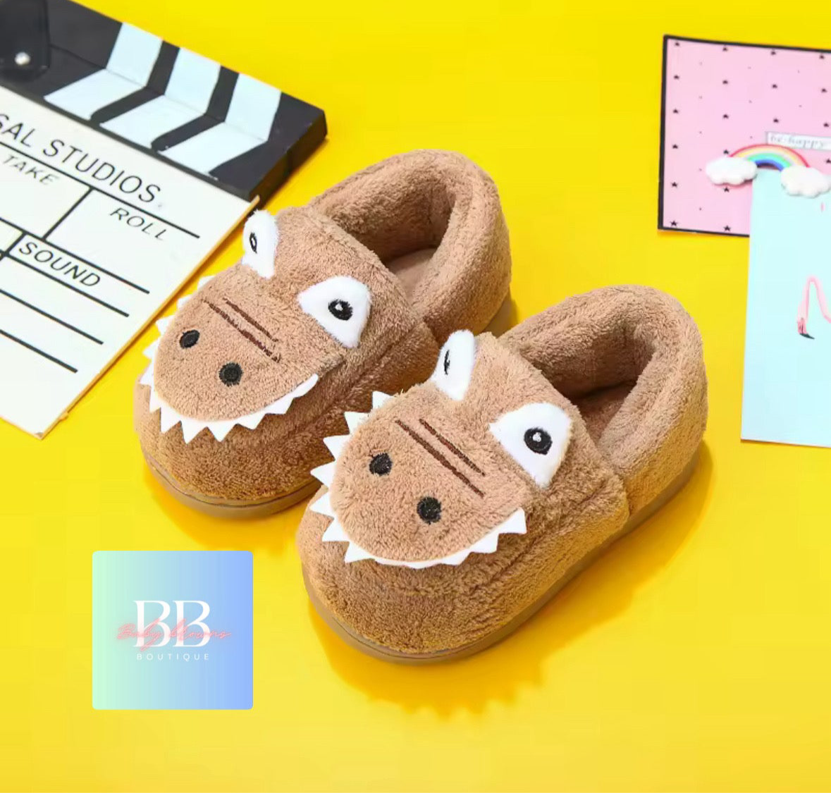 Brown slippers with animal face design on a yellow background