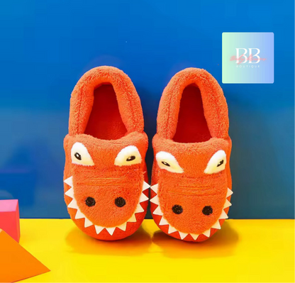Pair of orange children's slippers with fox design on a blue and yellow gradient background.