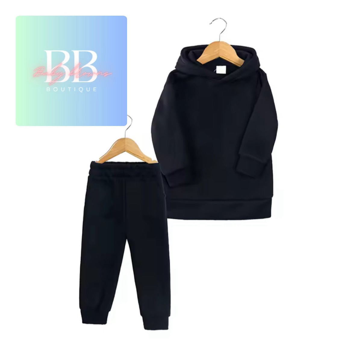 Black hoodie and pants set on hangers with a 'BB Boutique' sign in the background.