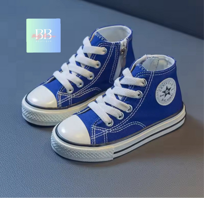 Blue high-top sneakers with white laces on a gray surface, featuring a brand logo in the corner.