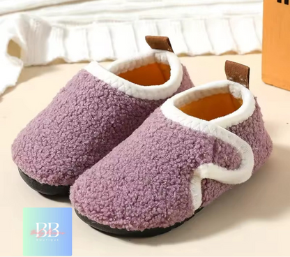 Pair of purple slippers with white trim on a light background