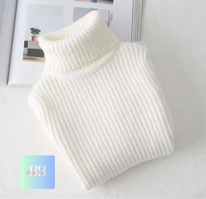 White ribbed sweater on a light gray surface with a blurred magazine in the background