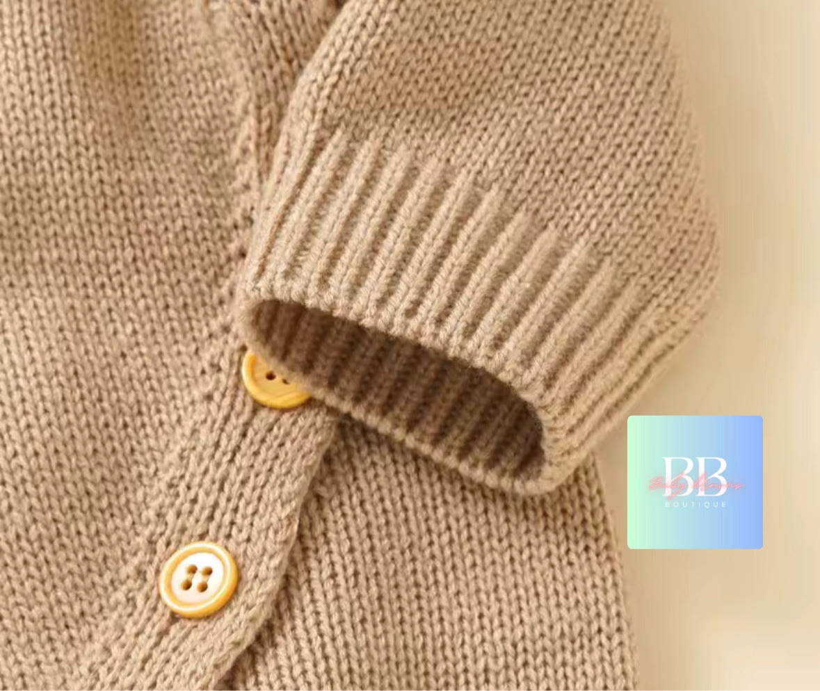 Close-up of a brown knitted sweater with buttons on a beige background