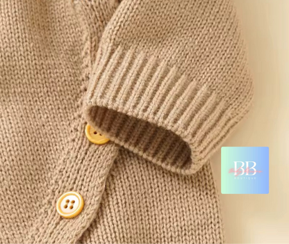 Close-up of a brown knitted sweater with buttons on a beige background