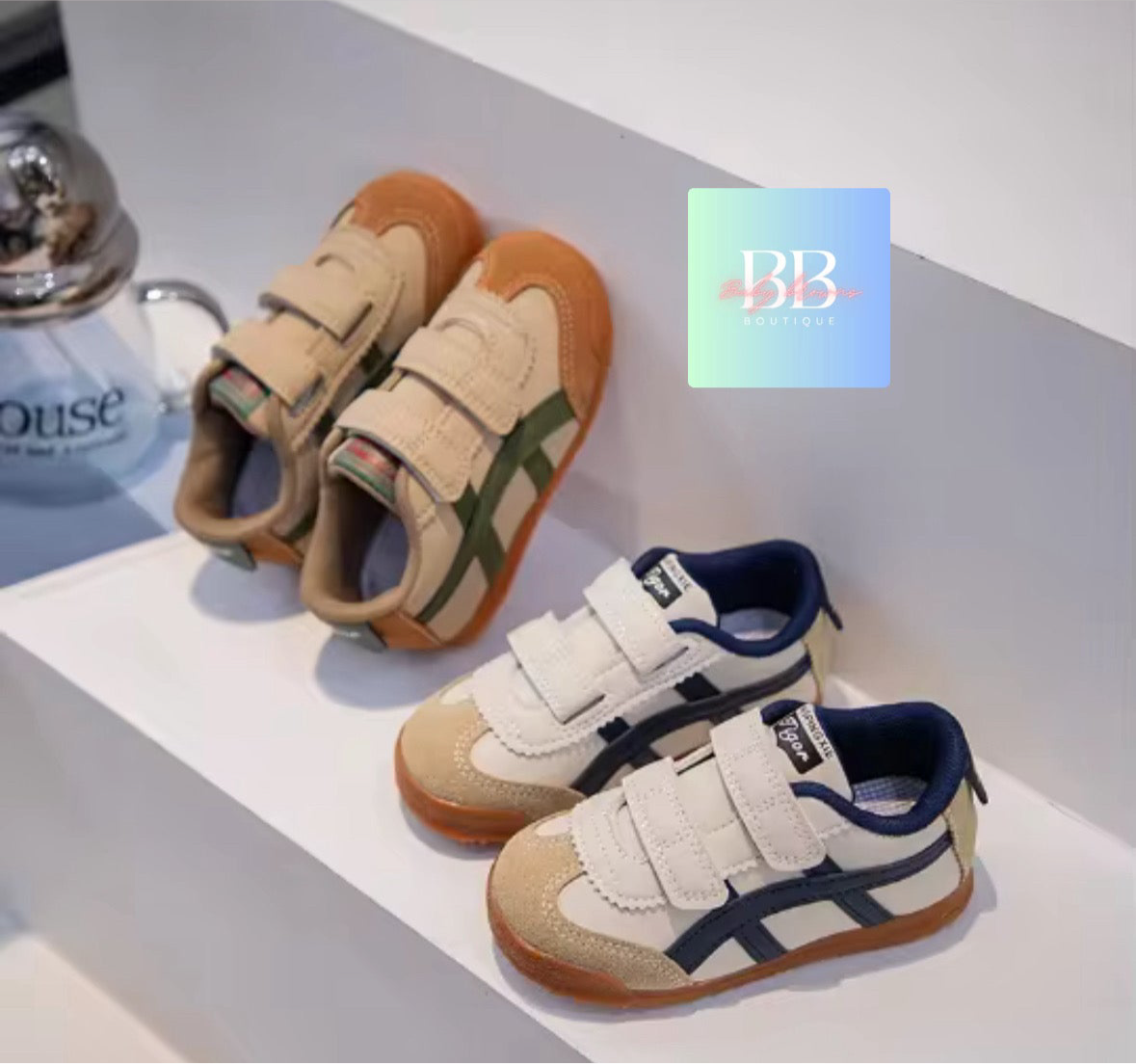 Pair of children's sneakers with a visible brand logo on a light gray background