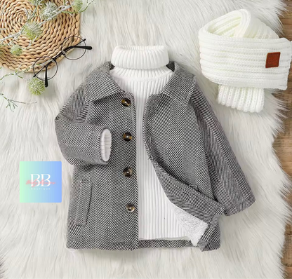 Gray herringbone coat with white turtleneck sweater on a fluffy white surface