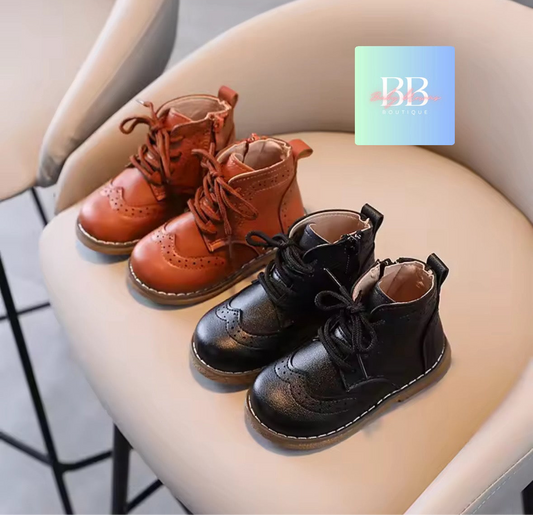 Pair of brown and black children's boots on a chair with a brand logo in the corner.