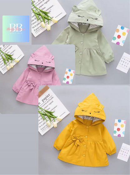 Three children's hoodies in green, pink, and yellow on a gray background with decorative elements.