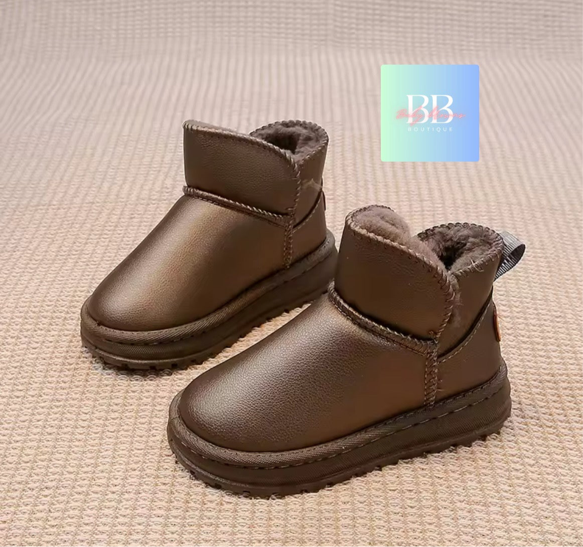 Pair of brown children's boots on a textured beige surface with a brand logo in the corner.