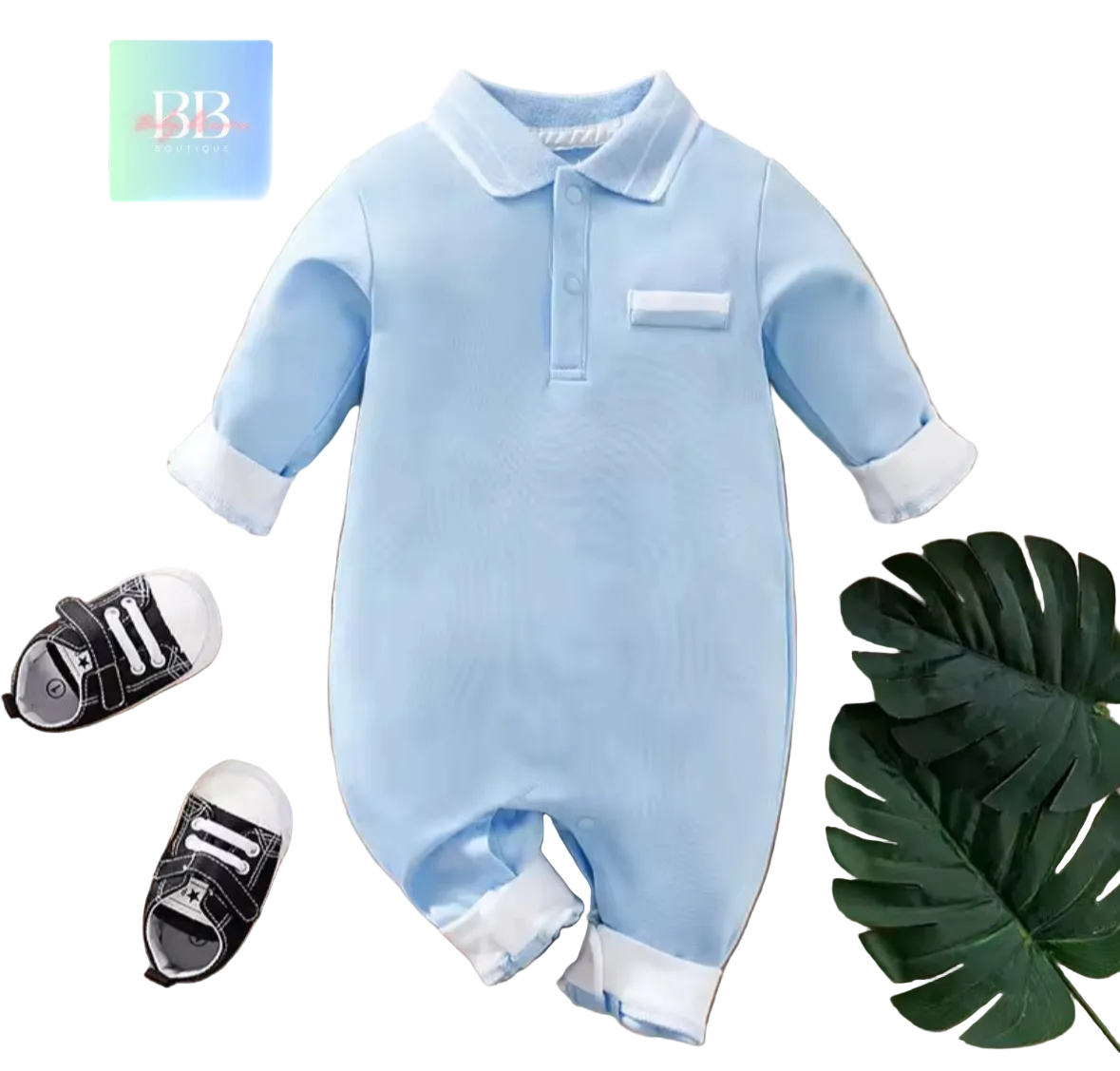 Blue baby onesie with white trim on a wooden surface with baby shoes and a leaf.