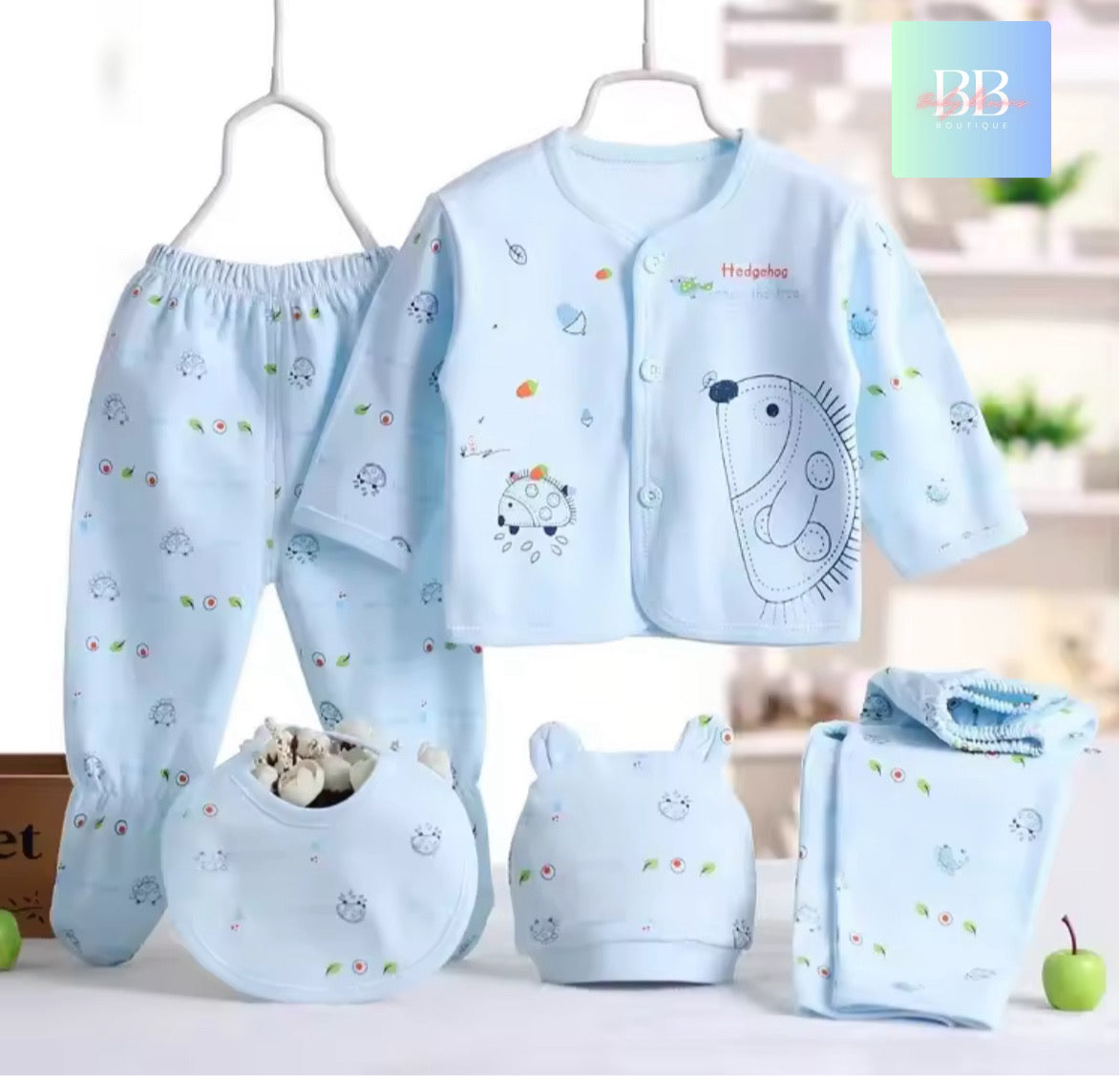 Baby clothing set with a shirt, pants, and accessories on a white background.