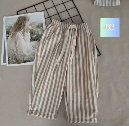 Striped pants on a textured surface with a blurred photo and brand logo in the background