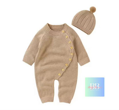 Beige knitted baby romper with yellow buttons and matching hat on a white background