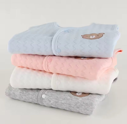 Stack of folded baby clothes with bear designs on a light gray background soft cotton waistcoat/bodywarmer
