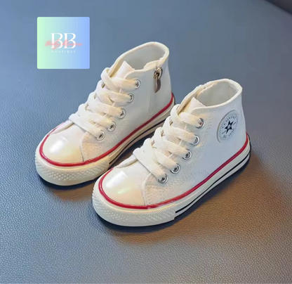 White high-top sneakers with red accents on a gray surface, featuring a brand logo in the corner.