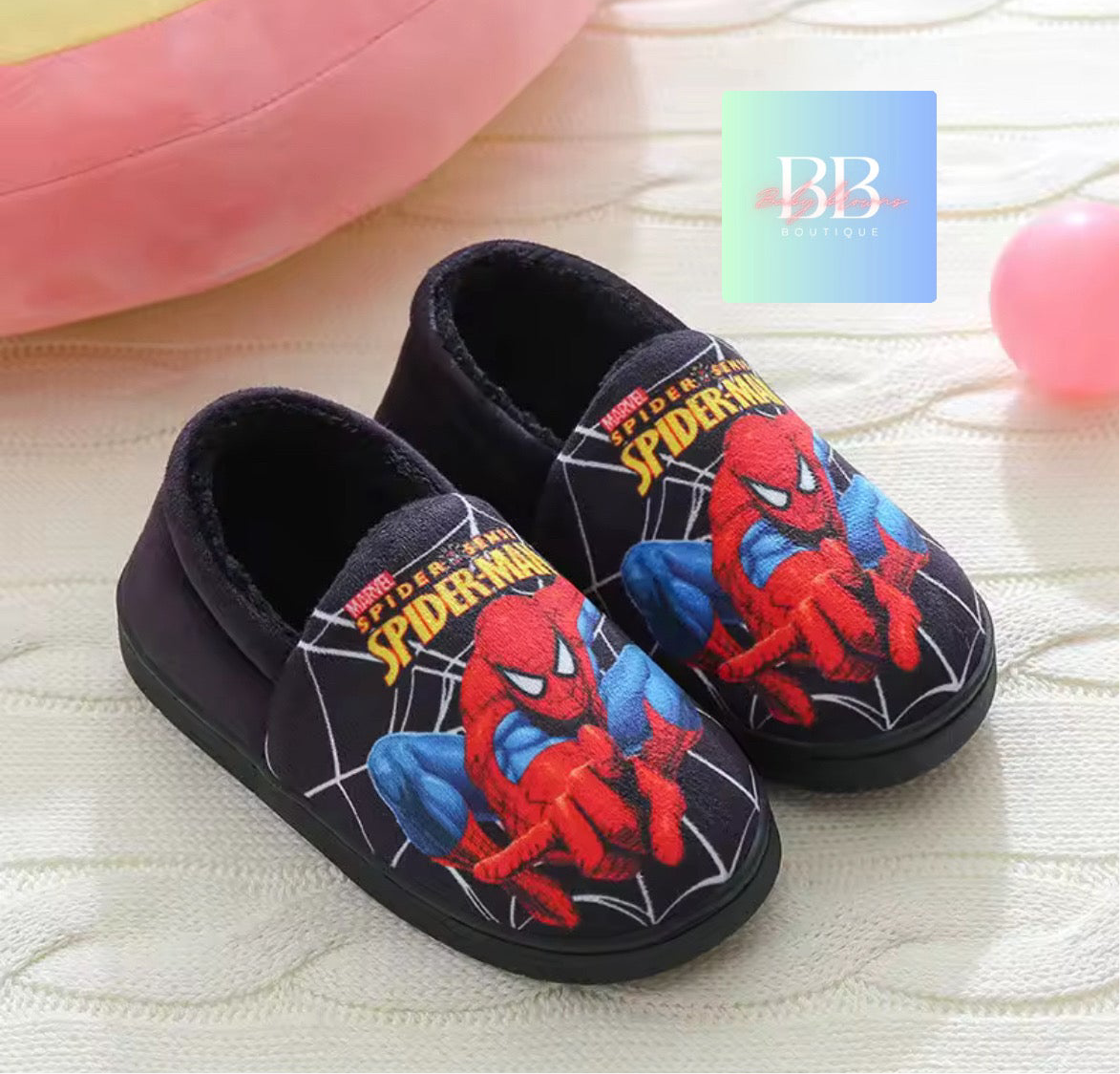 Spider-Man themed slippers on a textured surface with a visible brand logo.