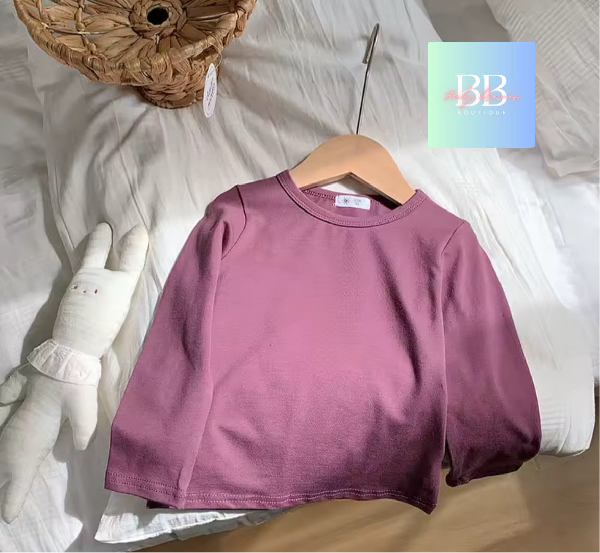 Purple sweatshirt on a wooden hanger with a soft white background