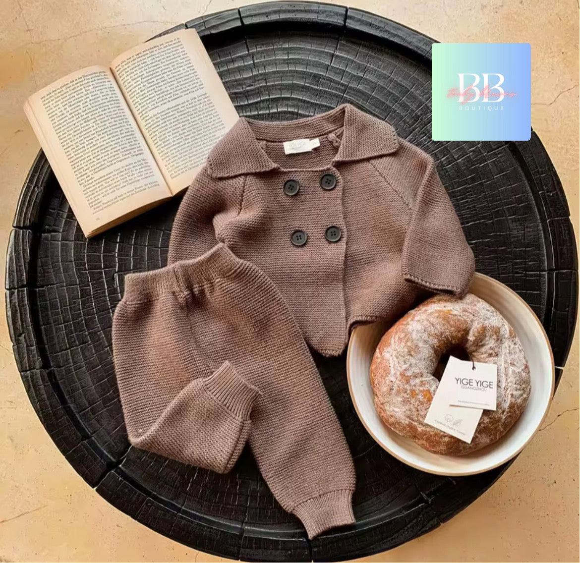 Children's brown outfit with a donut on a round black surface, featuring the brand 'BB'.