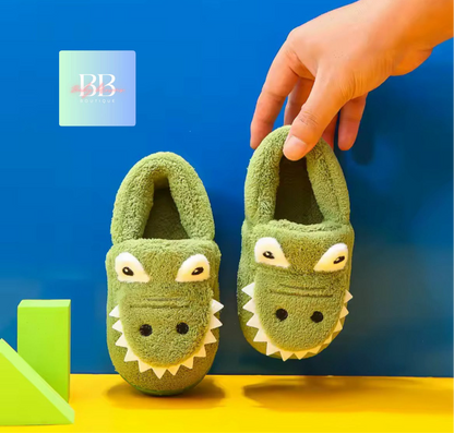Green crocodile-themed slippers on a yellow surface with a blue background